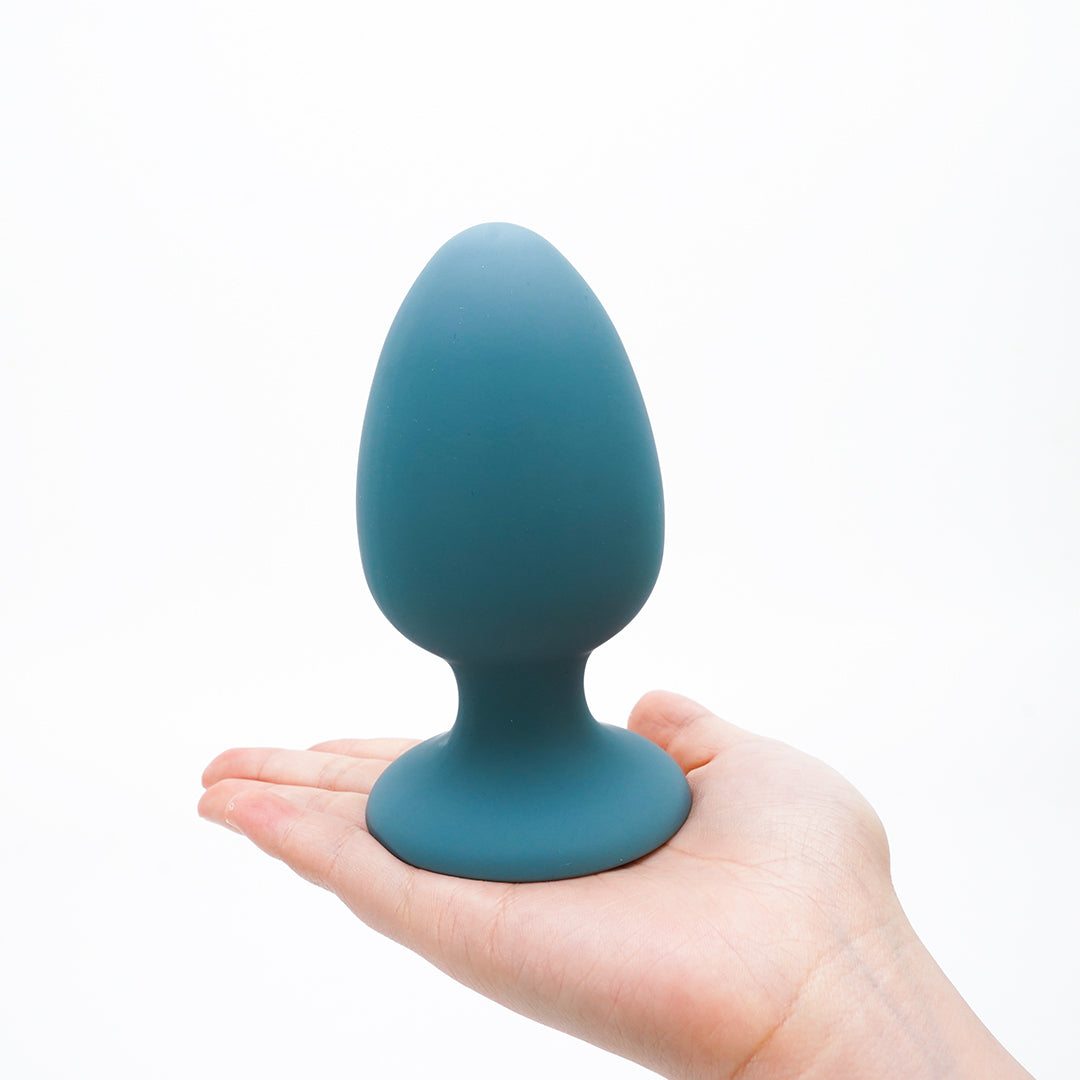 Teal anal plug held in hand, product detail