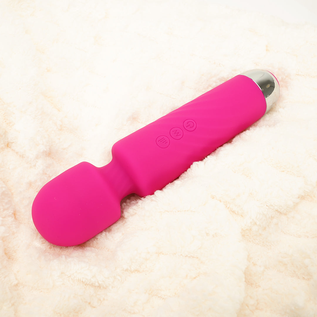 Pink massage wand on a white fluffy surface