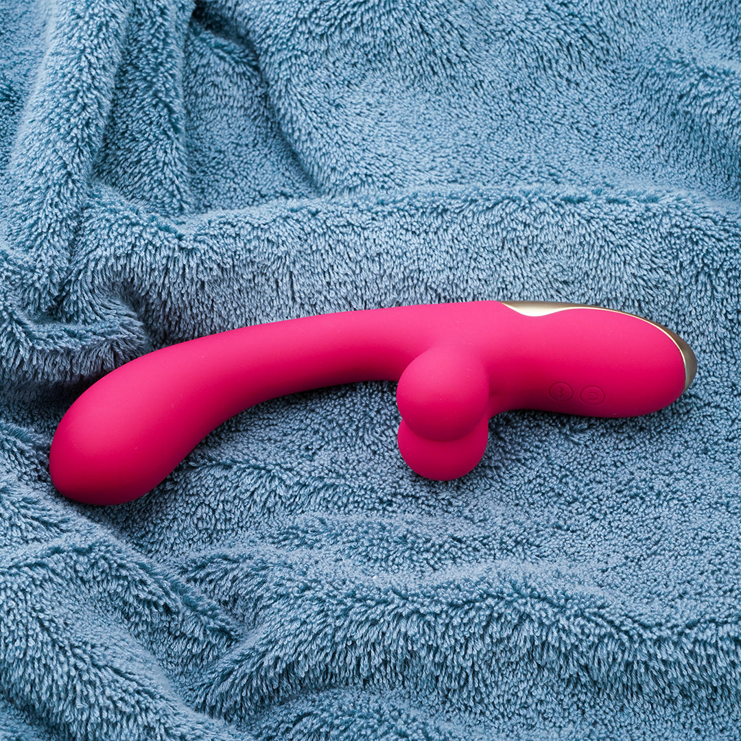 Pink Whale-p dual rabbit vibrator on plush fabric