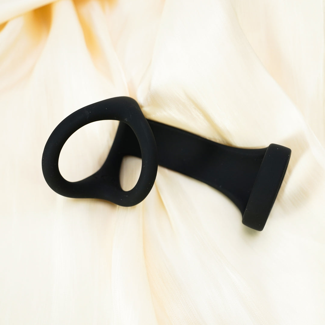 Black silicone penis ring on silky fabric