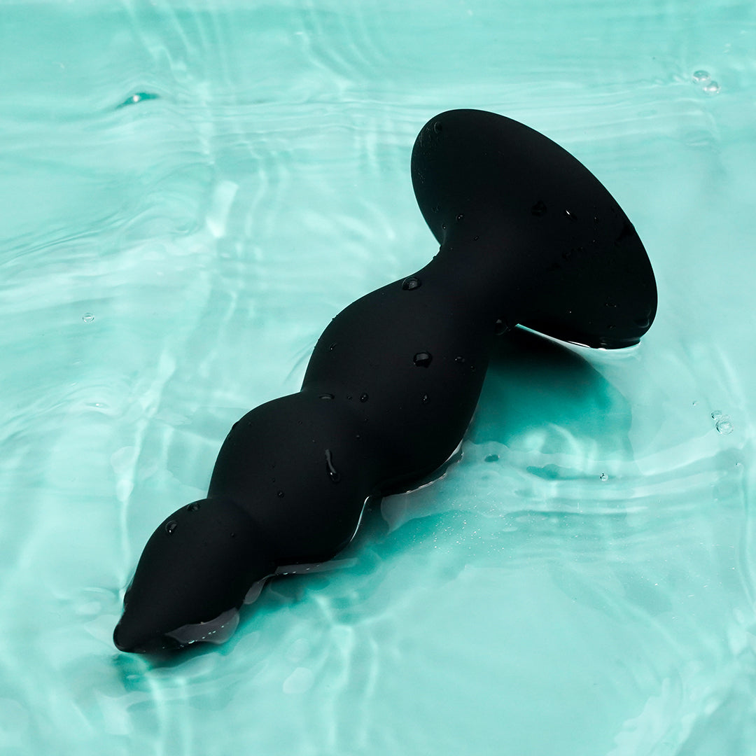 Black anal dildo with suction cup base, water background