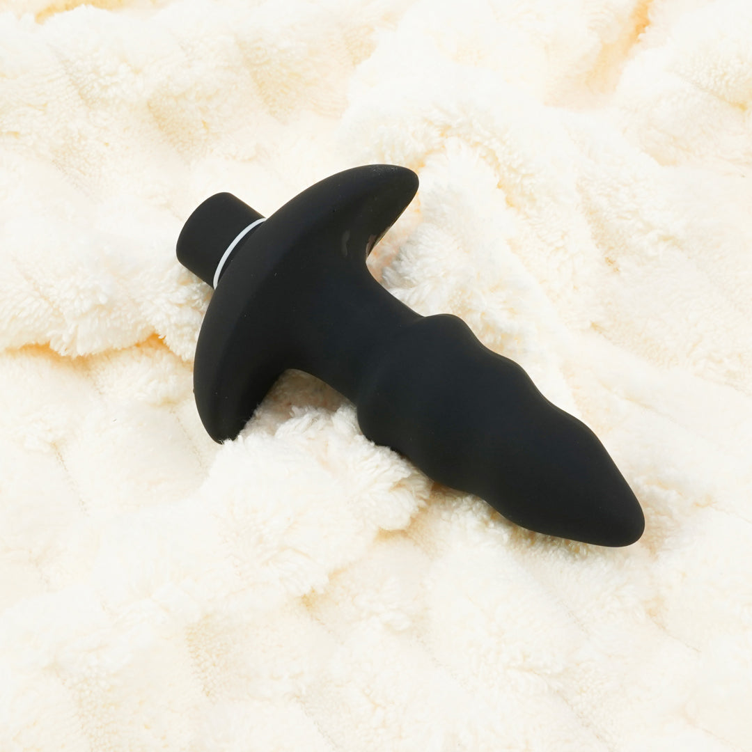 Love Earrow black silicone butt plug on cream fabric