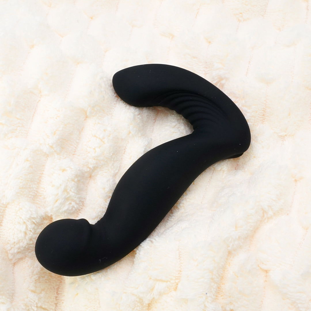 Black prostate massager on a soft, textured background