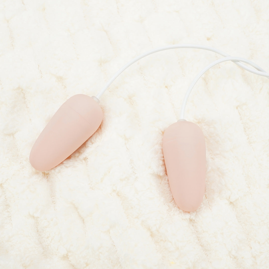 Pinecone Double Love Egg vibrator, peach color on soft texture