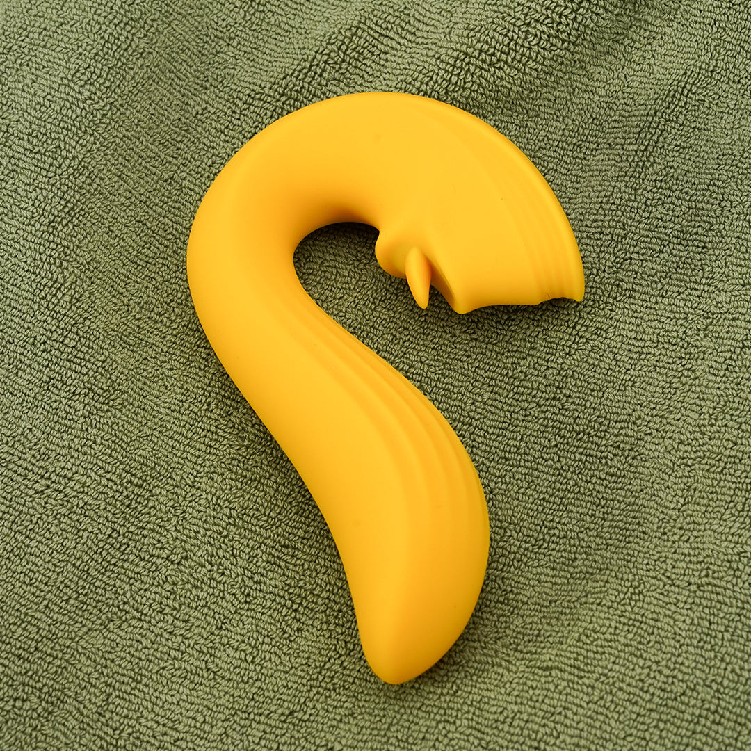 Yellow clitoral vibrator on green fabric