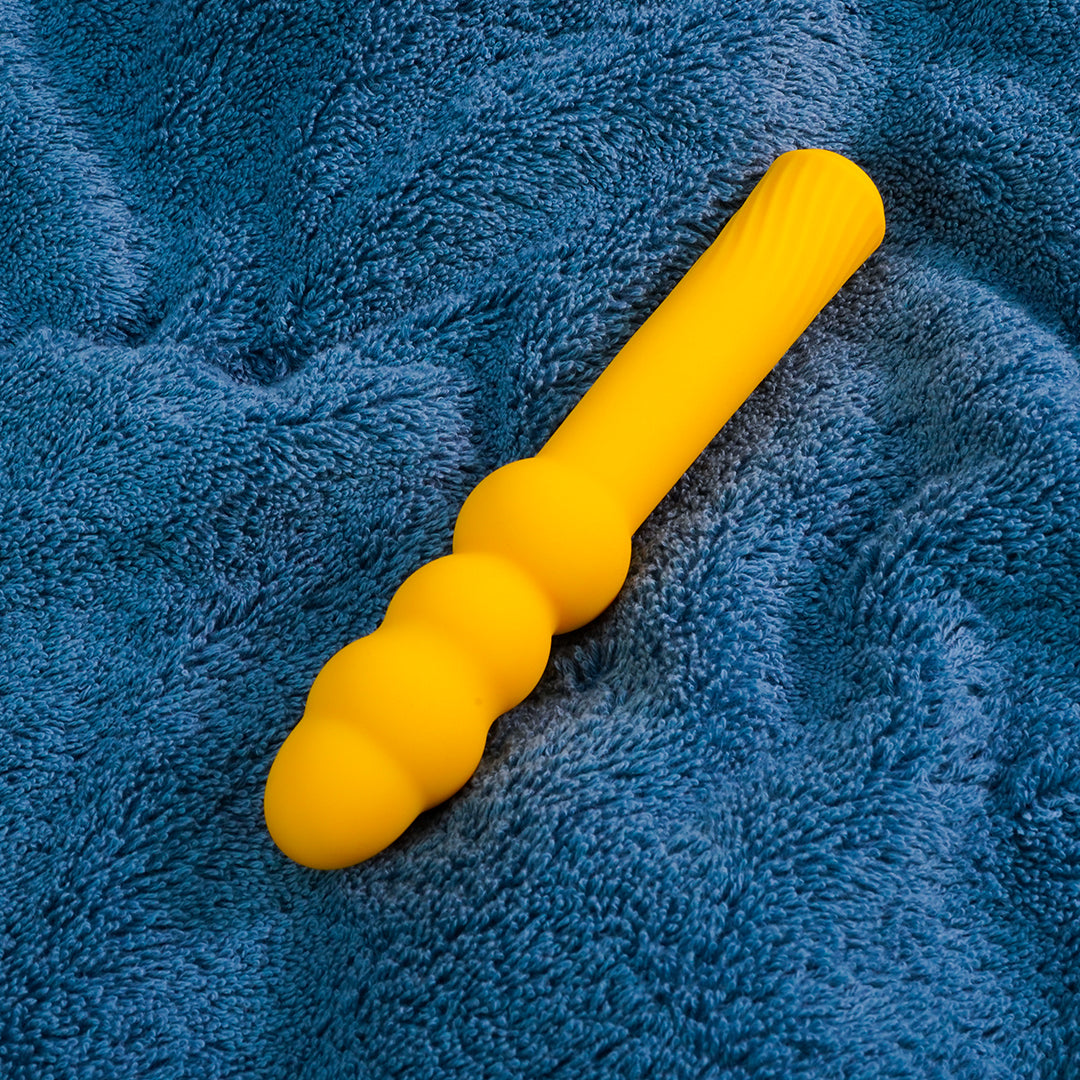 Yellow G-spot vibrator on blue background