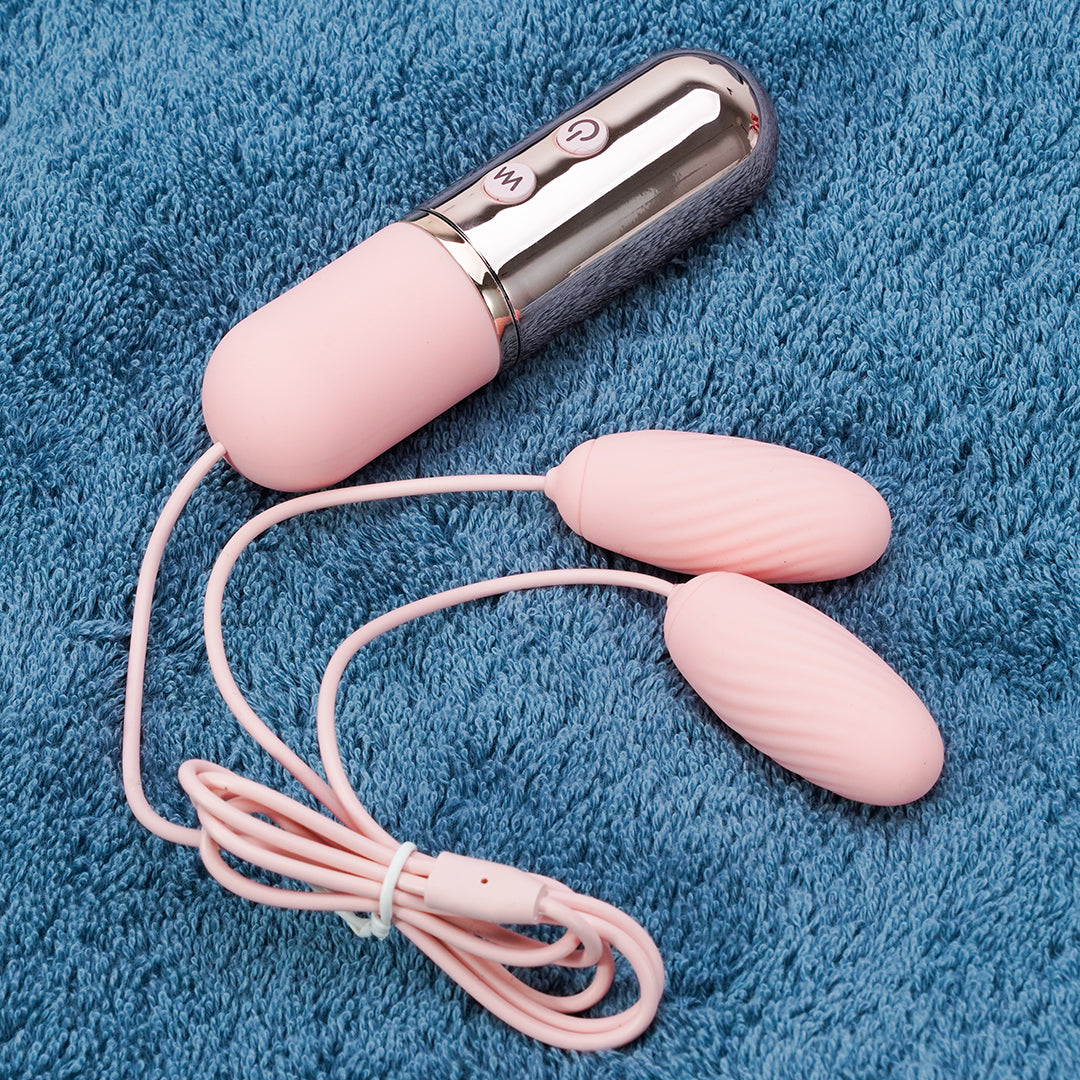 Pink clitoral vibrator love egg, USB charging, with blue towel background