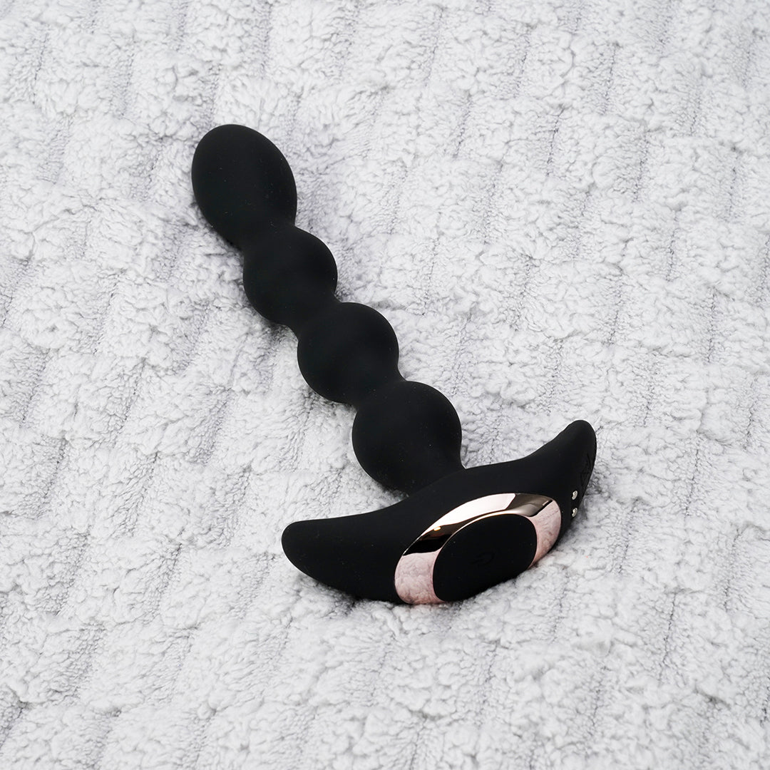 Curved black prostate massager with rose gold details