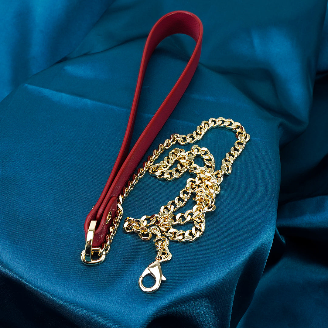 Red leather BDSM restraint with gold chain detail