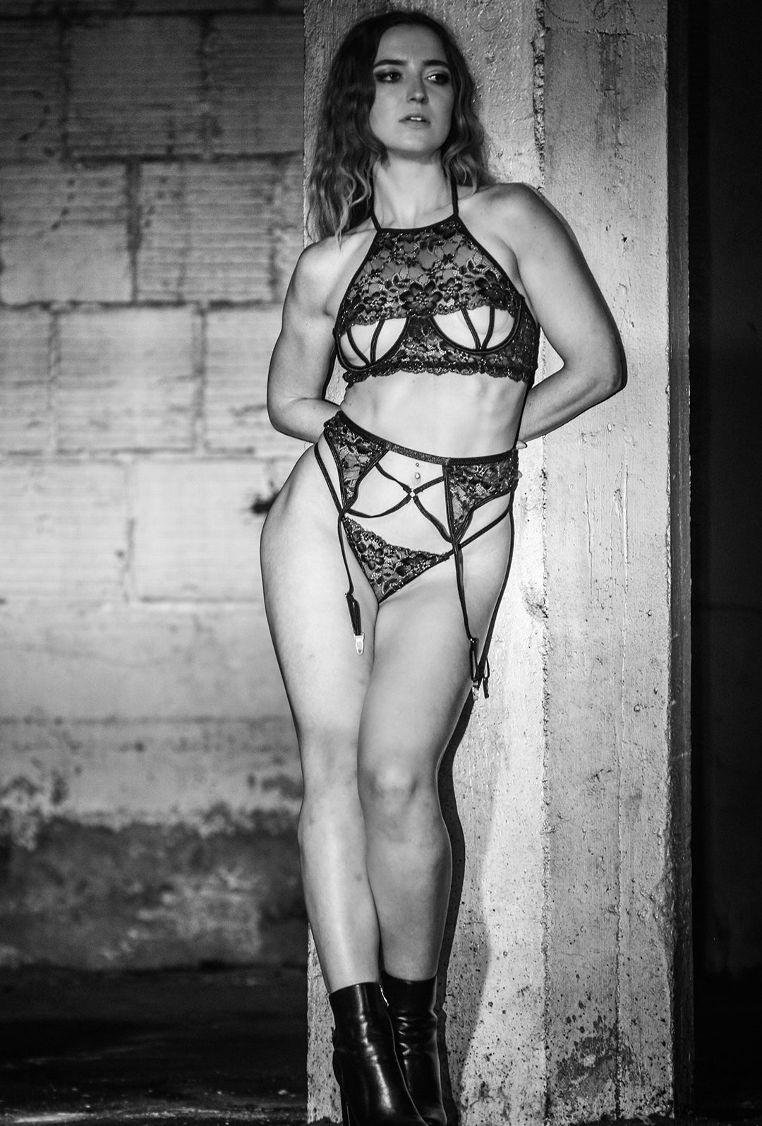 Black lace lingerie set with cross straps on woman, front view