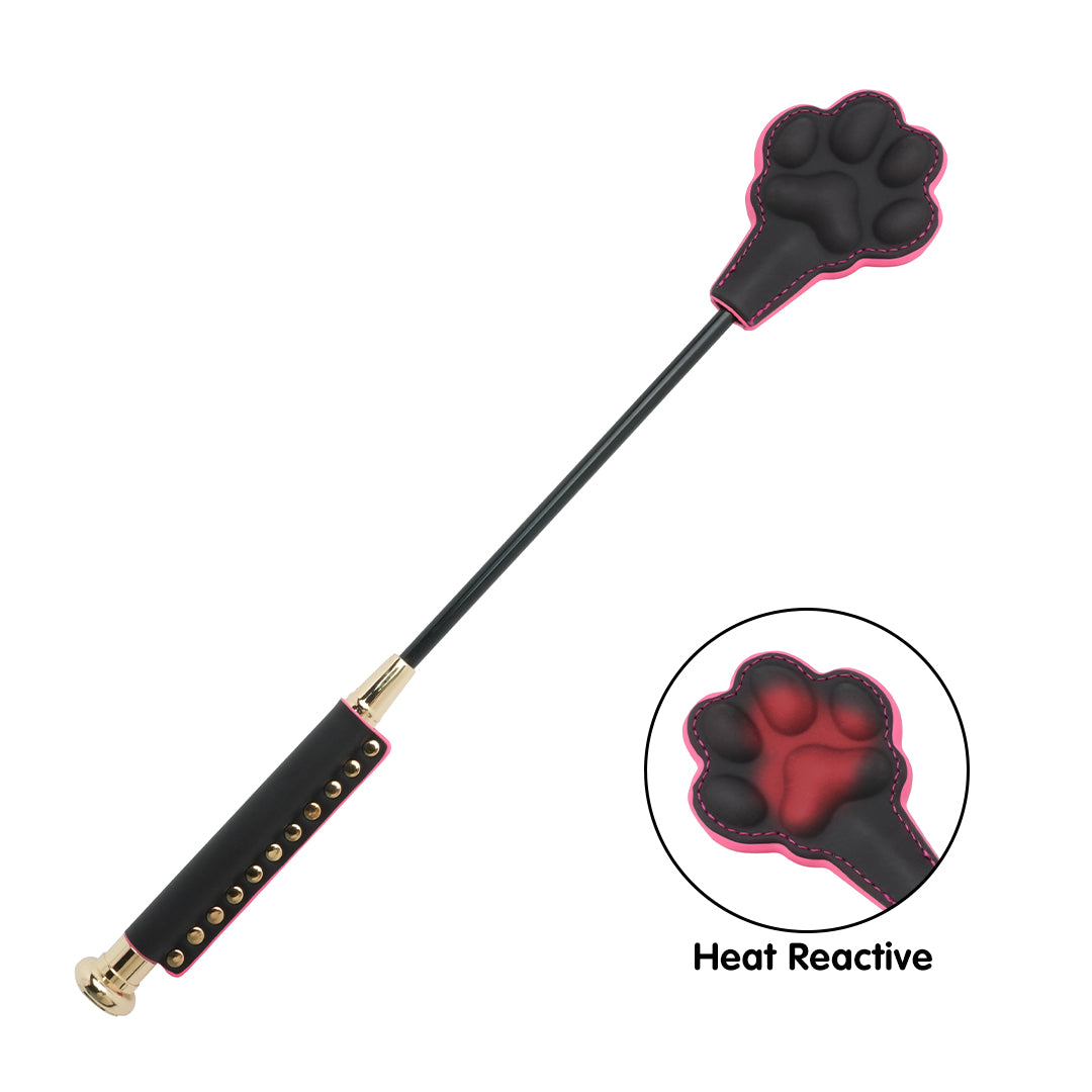 Cat paw heat reactive whip paddle, black with pink trim, changes color when heated, studded handle.