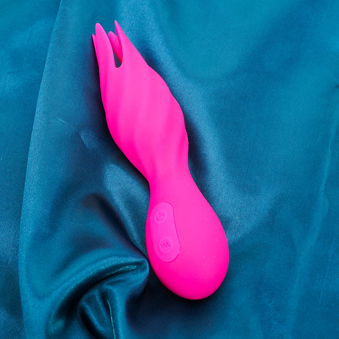 Pink lotus-shaped vibrator on teal fabric, clitoral stimulation