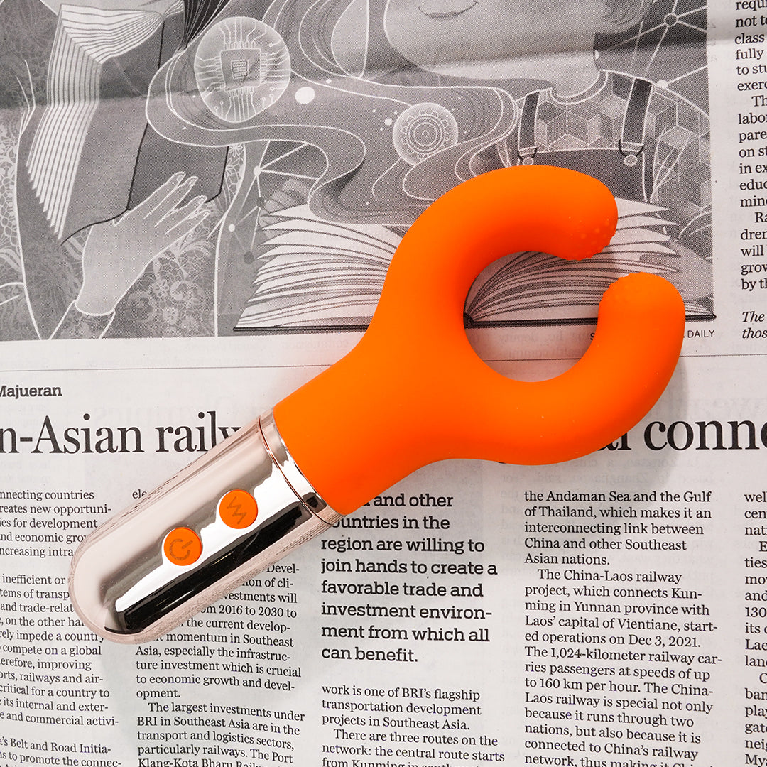 Donuts Clitoral Vibrator - Orange on newspaper background