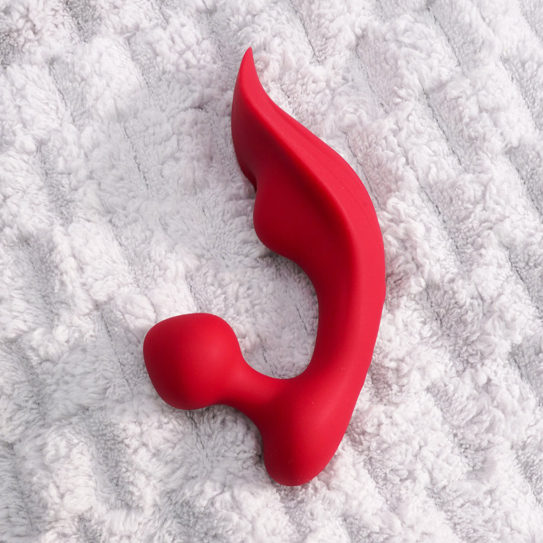 Red clitoral vibrator on white towel