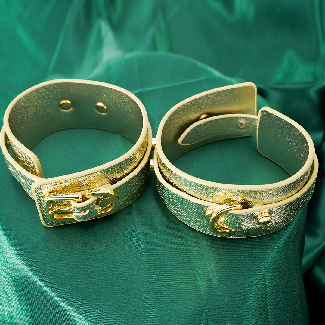 Gold luxury wrist cuffs on green background