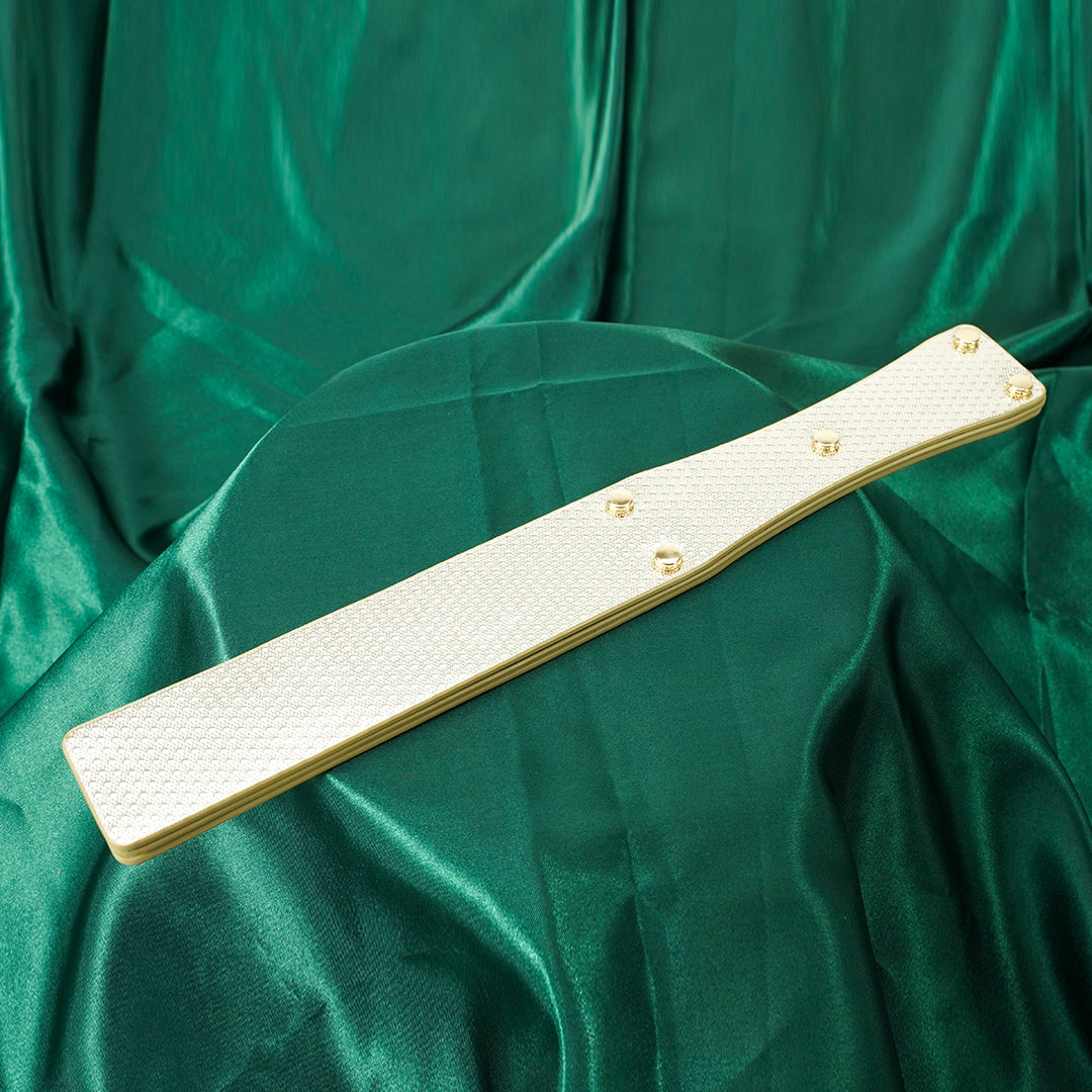 Gold BDSM paddle on green silk