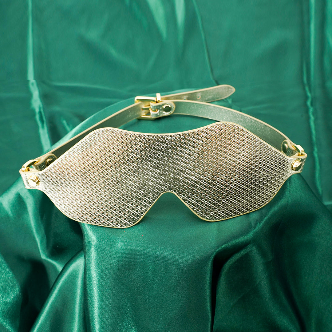 Gold BDSM eye mask on green silk