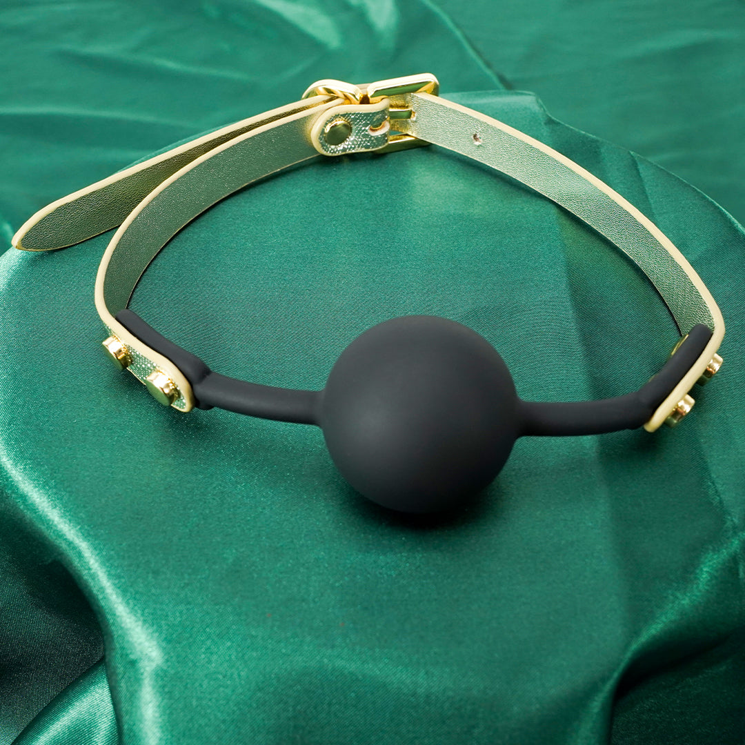 Gold and black BDSM ball gag